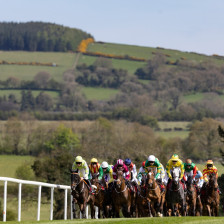 Along the main stretch horses racing at Punchestown with mountains in the background